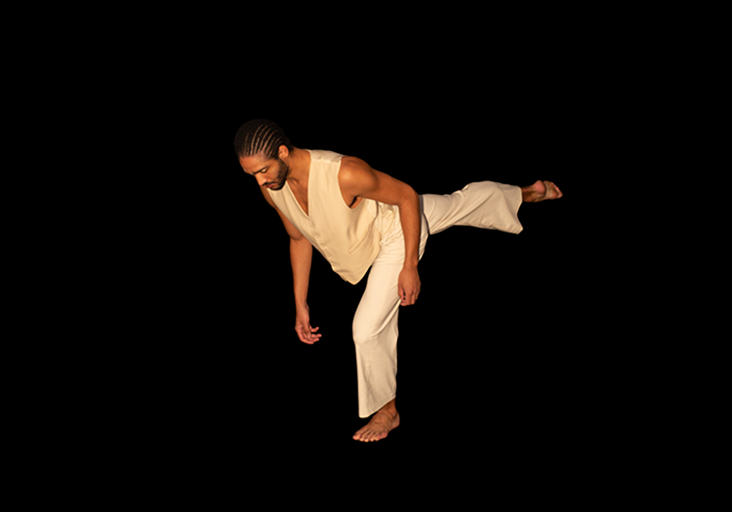 Harry holds a pose as he looks towards the floor with one leg behind him.